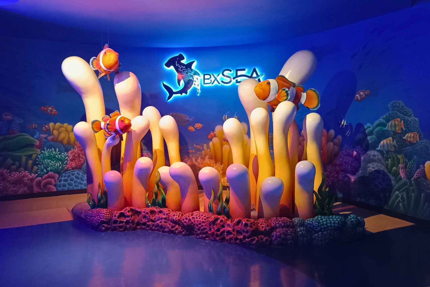 Themed clownfish and anemone exhibit beneath the glowing BX Sea logo, Jakarta