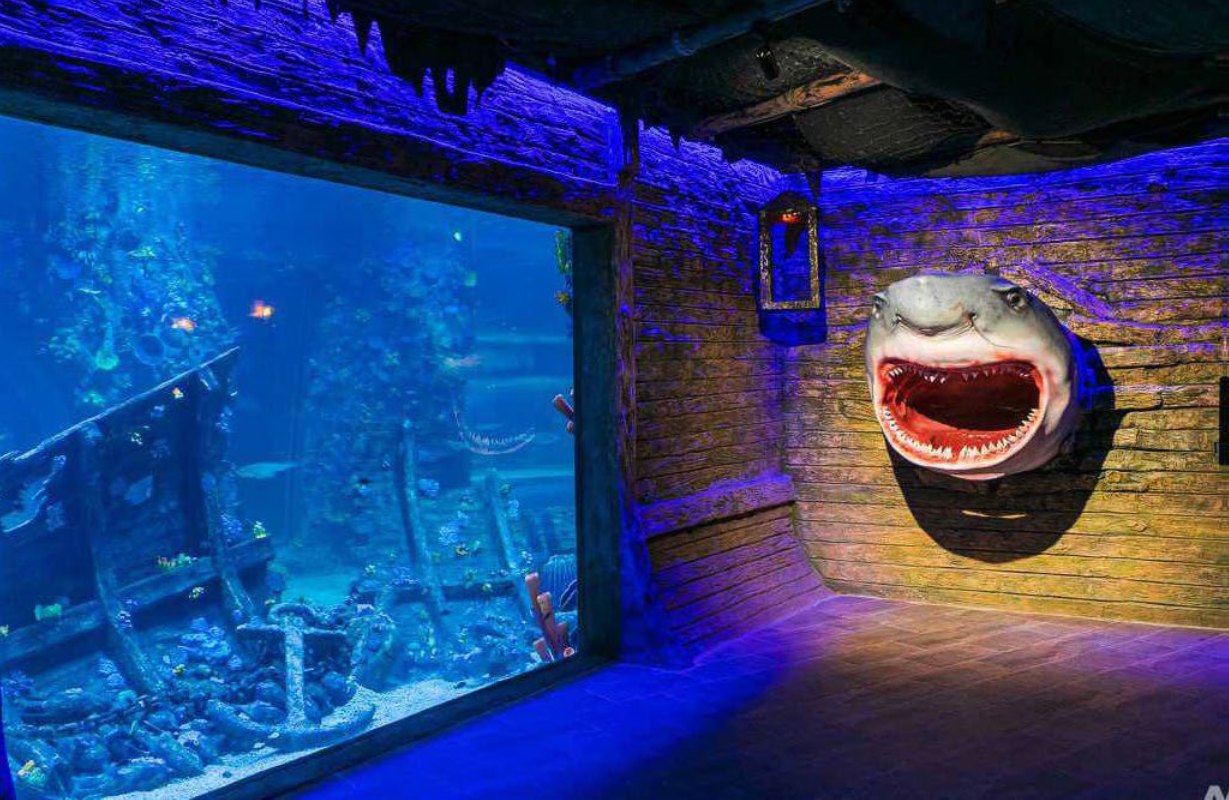 Steampunk submarine-themed corridor with a porthole tank at Magic City Aquarium, Tashkent