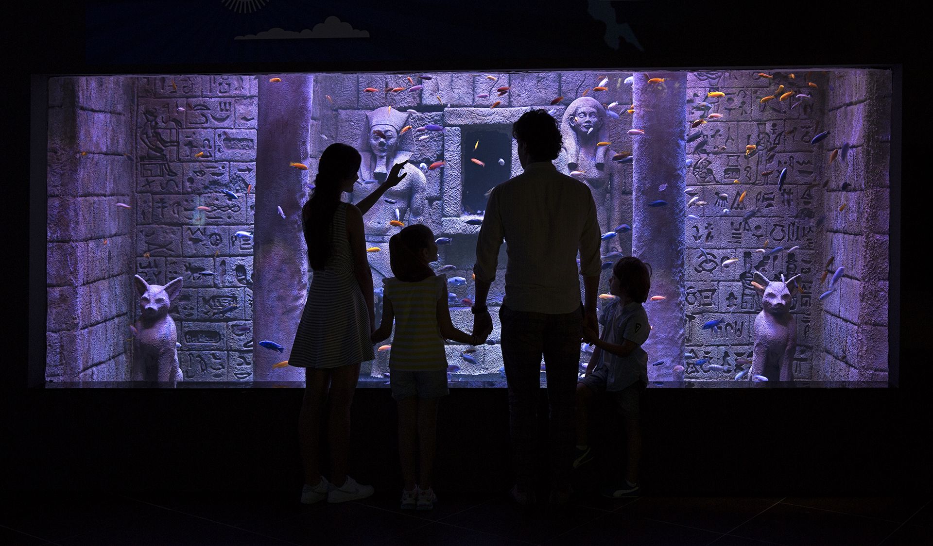 Family at the ancient-Egyptian themed tank with hieroglyphs and statues at Via Sea Aquarium, Istanbul